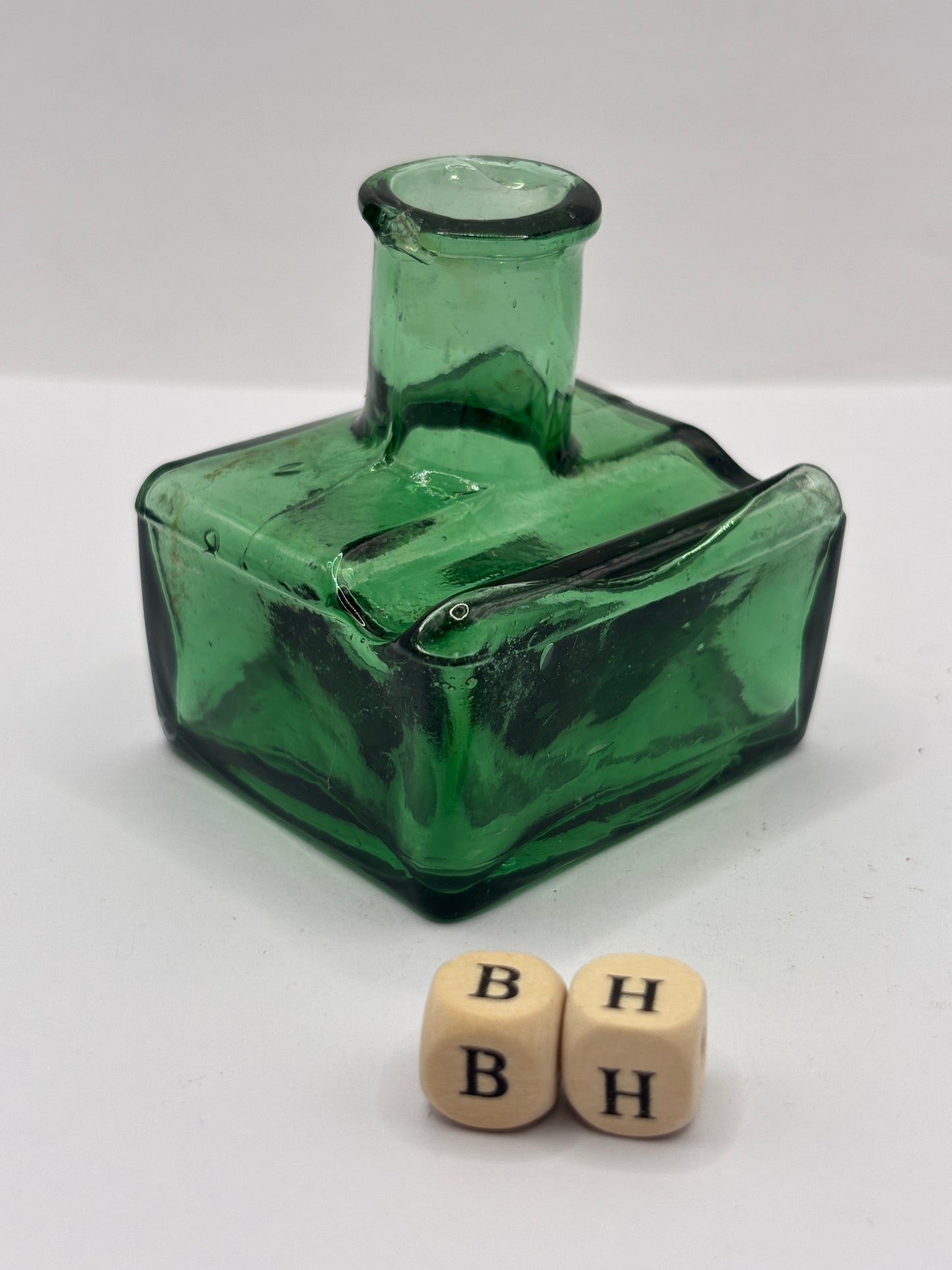 Old green glass ink bottle, inkwell. With pen rest (BH) chipped