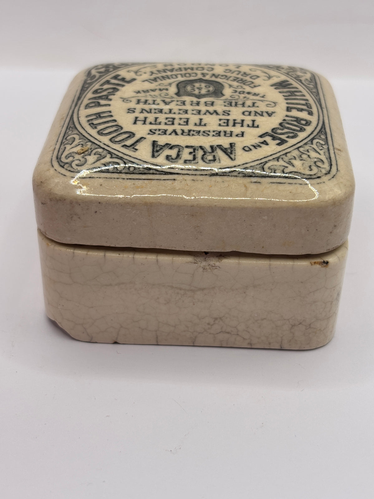 Old advertising lid and base. White rose and areca toothpaste. Damaged
