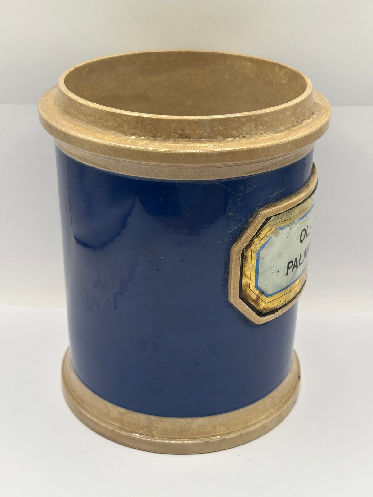 Old plain blue stoneware apothecary jar with glass label
