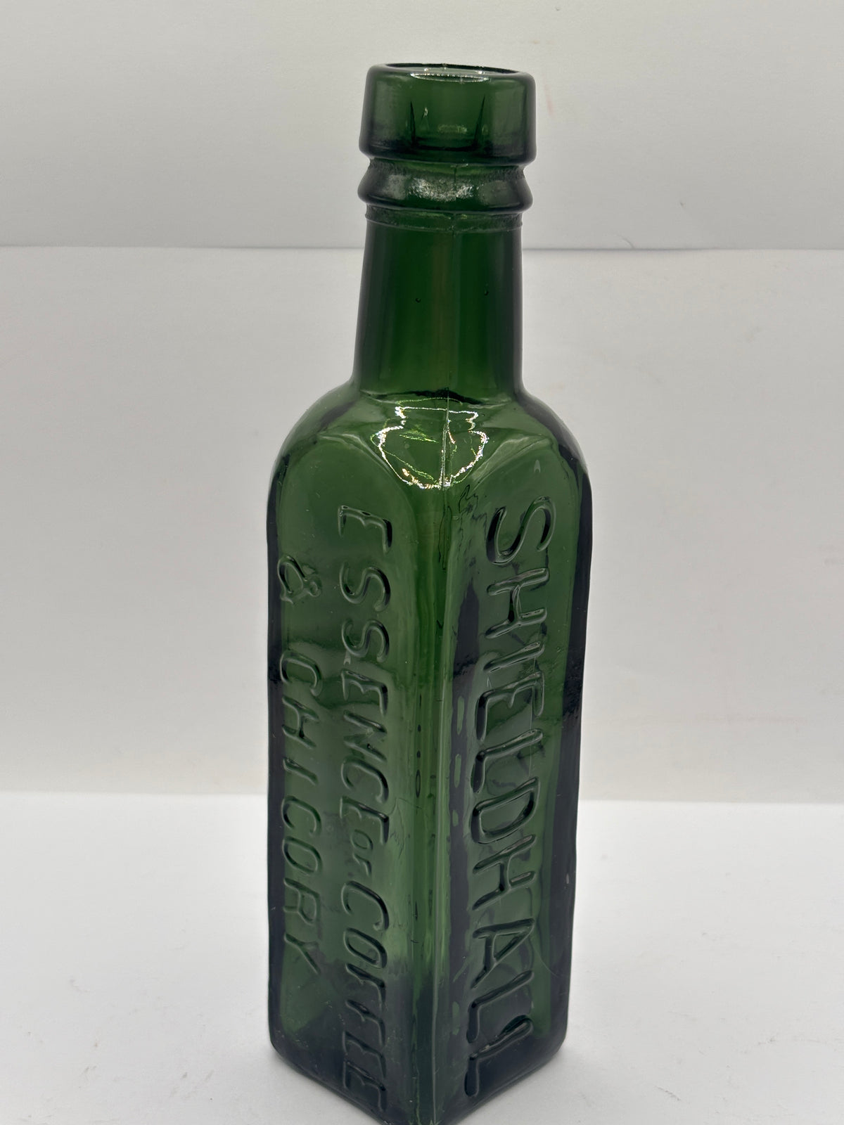 Old green glass essence of coffee bottle
