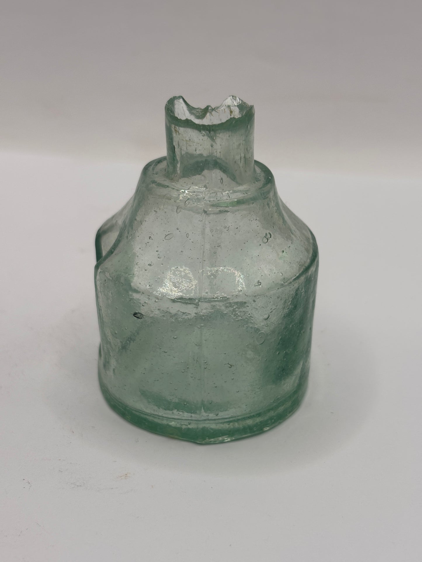 Old round aqua glass inkwell. Ink bottle with pen rest