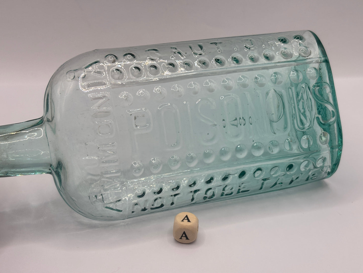 Old aqua glass poison bottle, (a) ammonia, poisonous