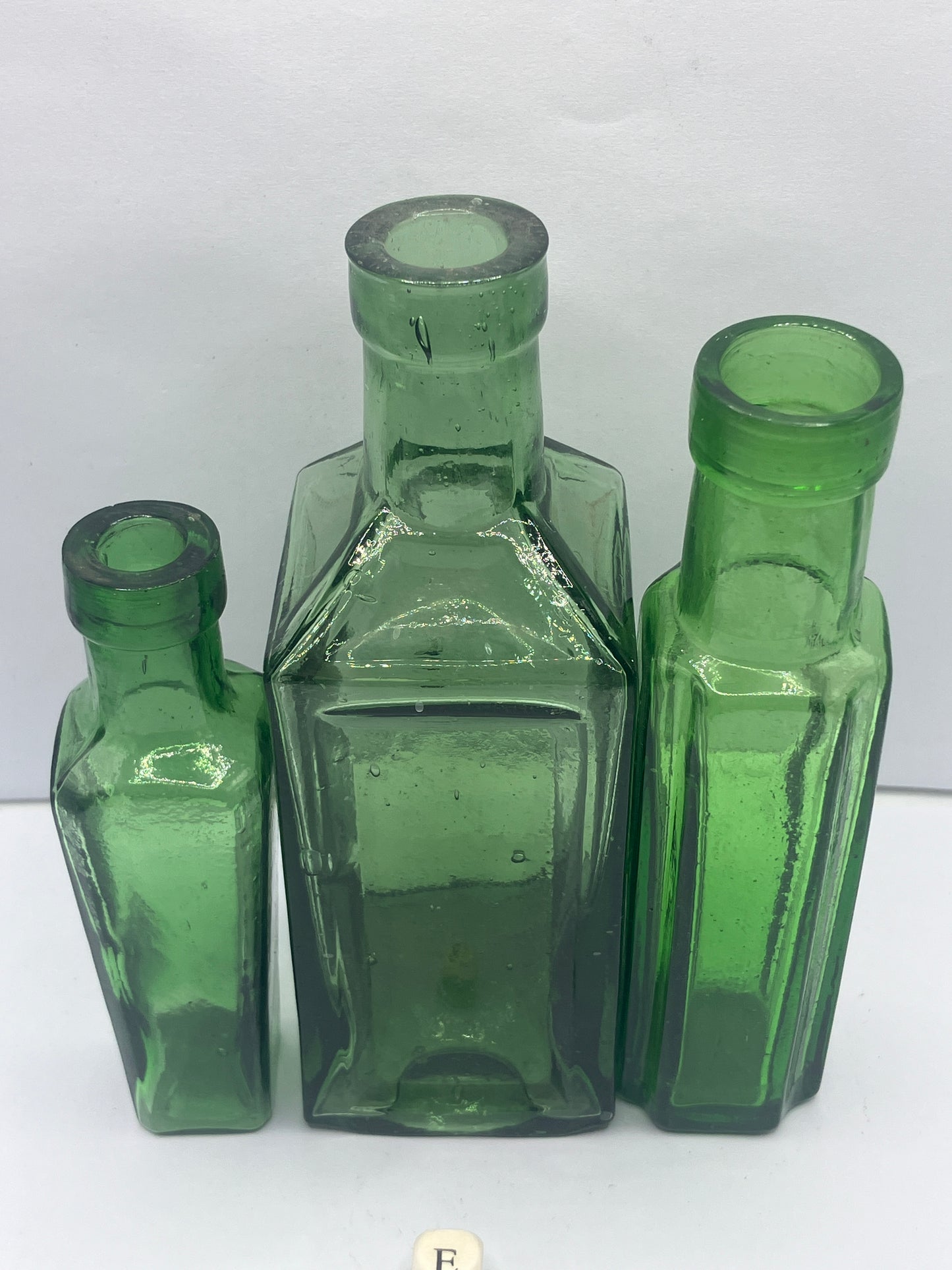 3 tall green glass bottles