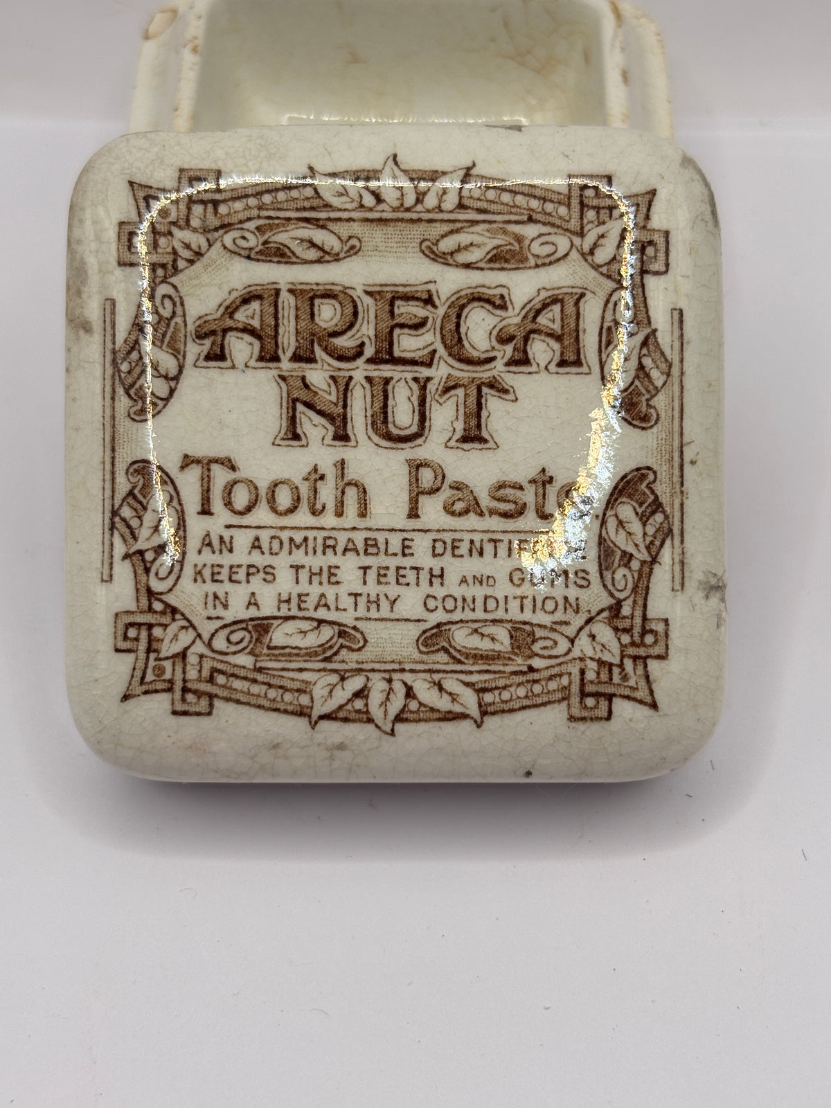 Old advertising lid and base. Areca nut toothpaste. Serpia print. Damaged