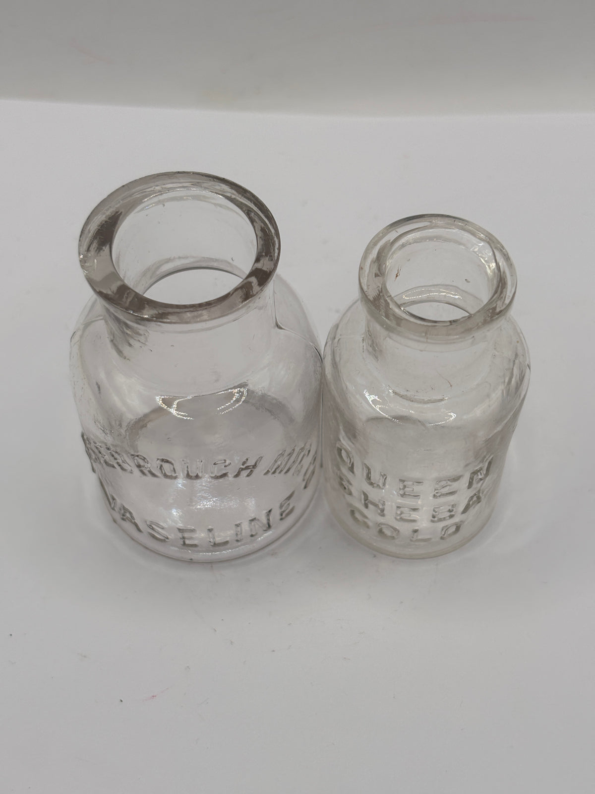 2 small clear glass advertising jars