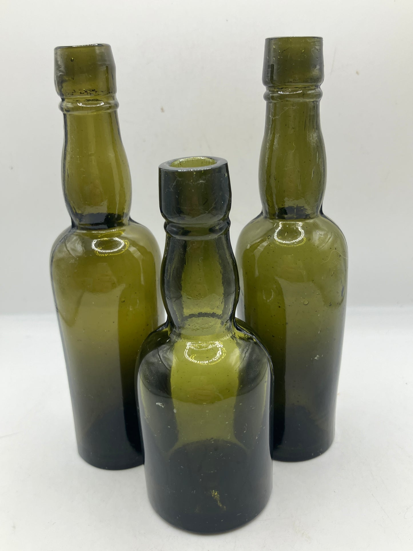 3 small green glass whisky bottles