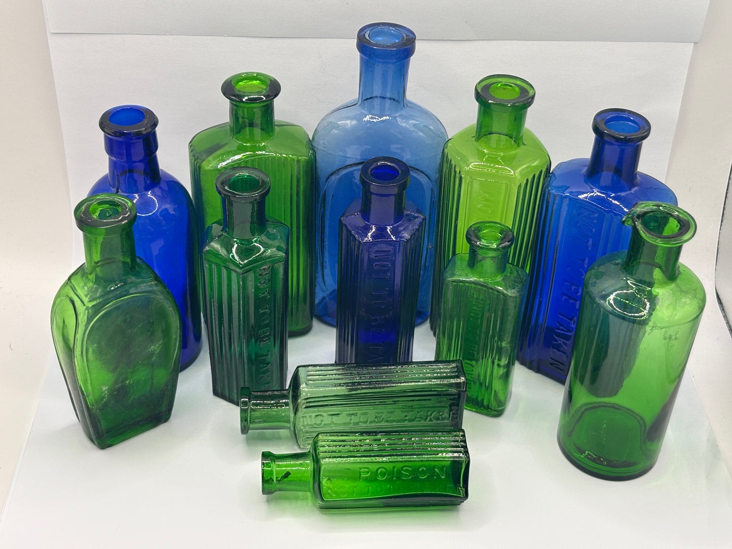 12 old coloured glass bottles, poison bottles & chemist bottles