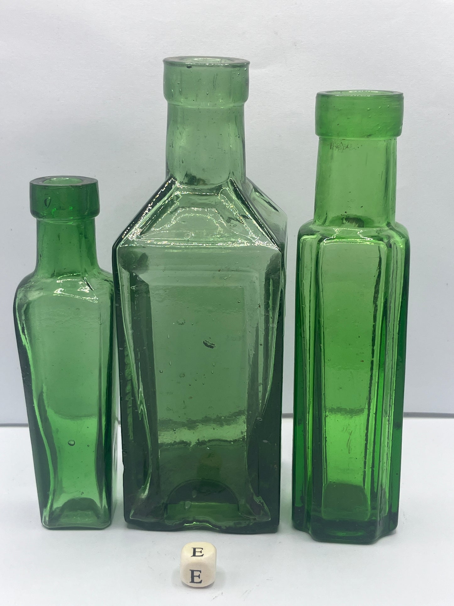 3 tall green glass bottles