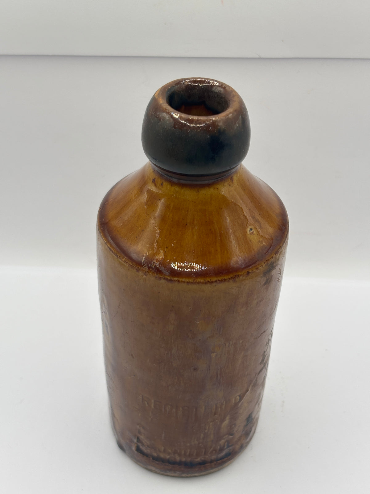Old impressed stoneware ginger beer bottle, Manchester. Brown top