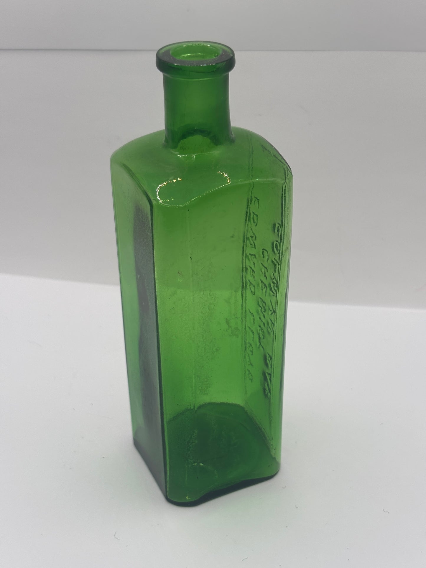 Old green glass advertising chemist bottle. Edward Lloyd chemist Colwyn bay