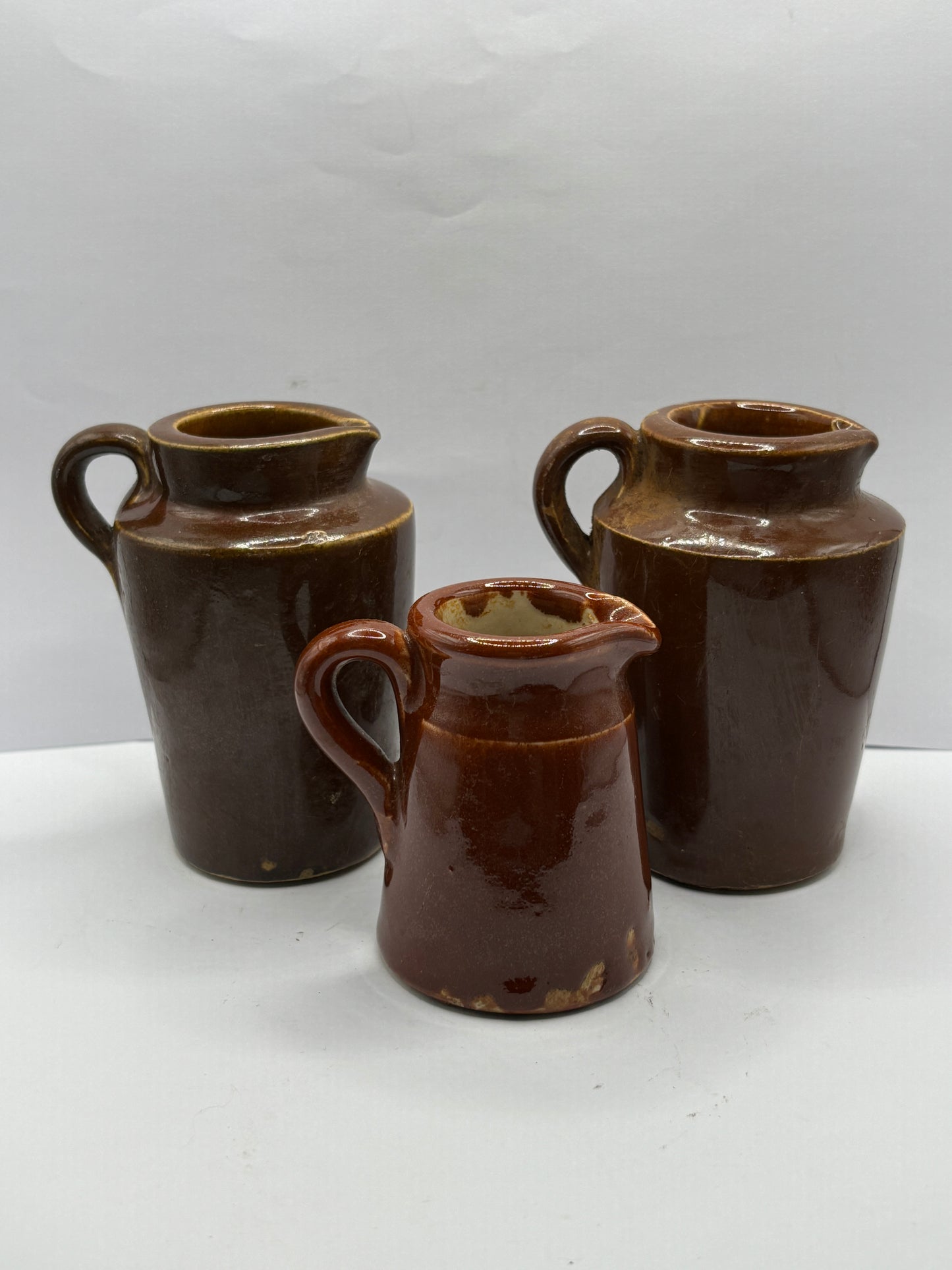 3 old brown stoneware cream pots, handled