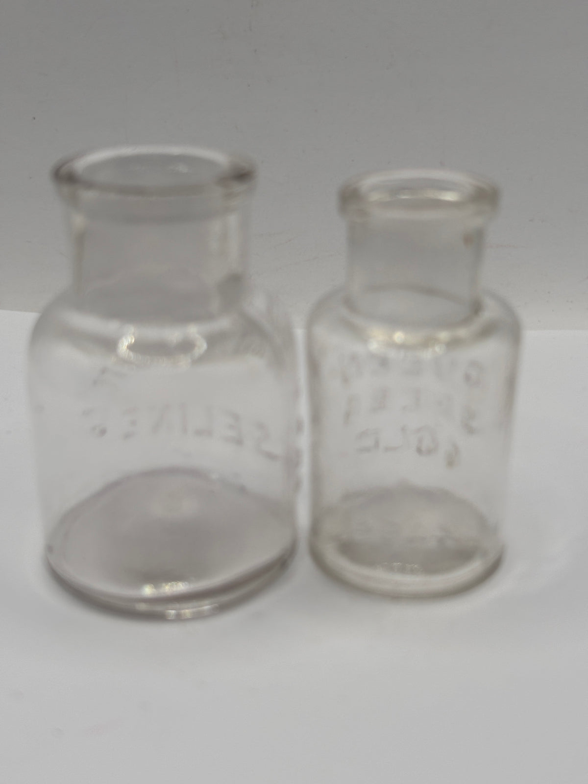 2 small clear glass advertising jars