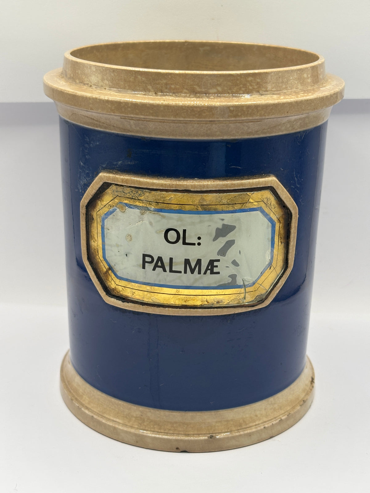 Old plain blue stoneware apothecary jar with glass label