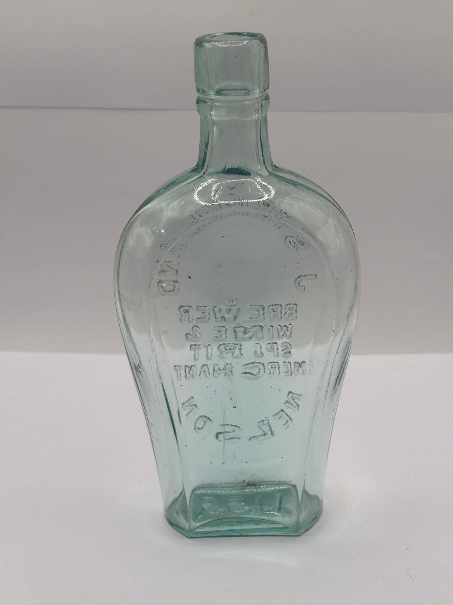 Old glass spirit flask, J.Strickland brewer wine & spirit merchant. Nelson