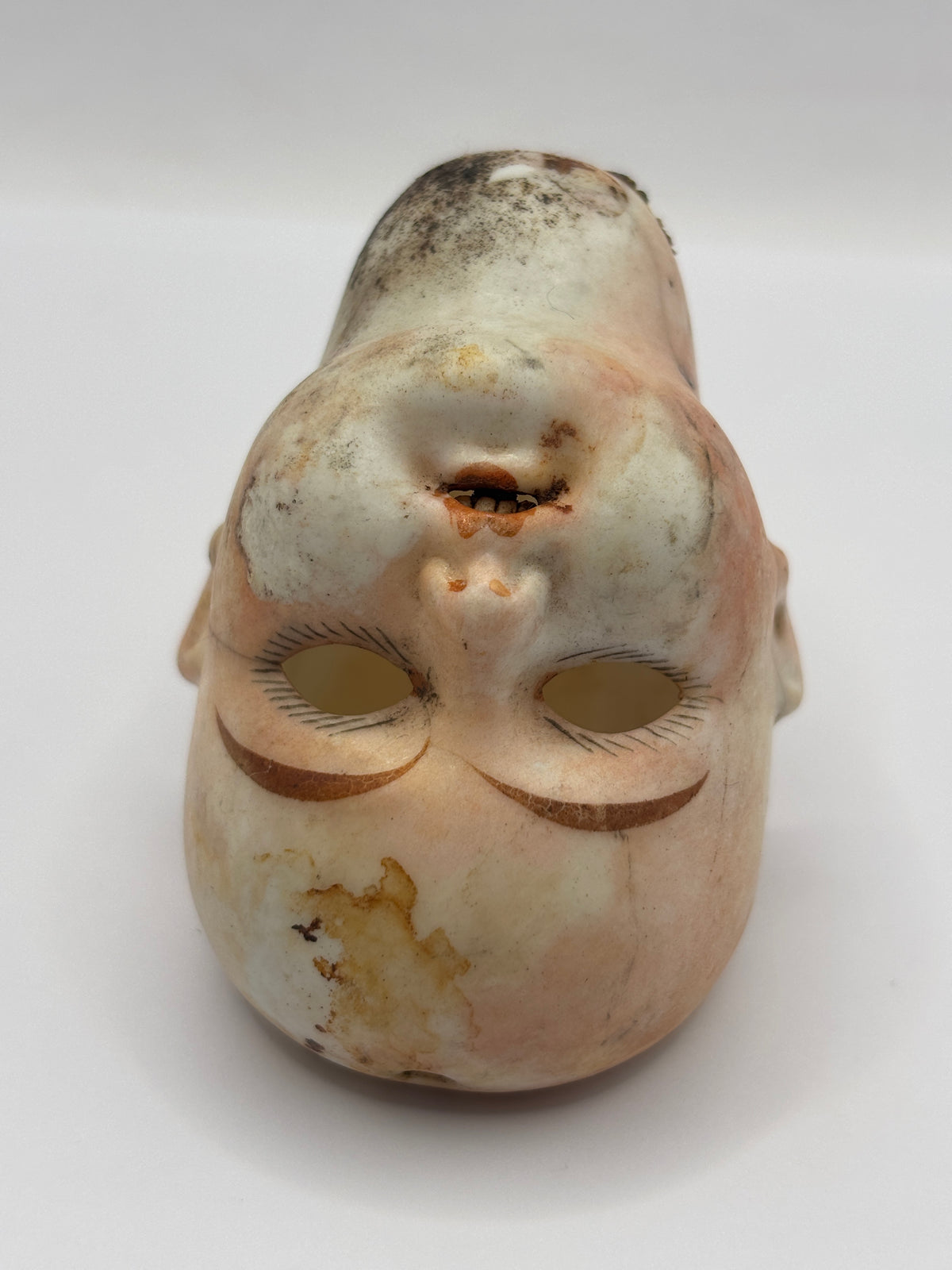 Old super stained bisque dolls head, damaged