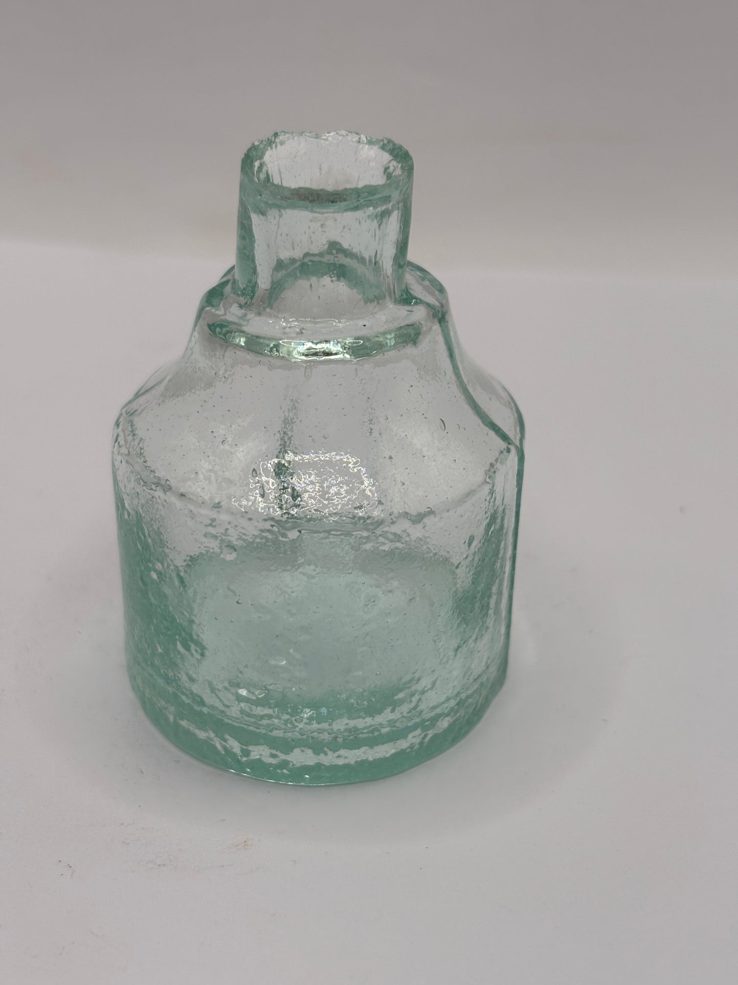 Old aqua glass inkwell. Ink bottle with pen rest