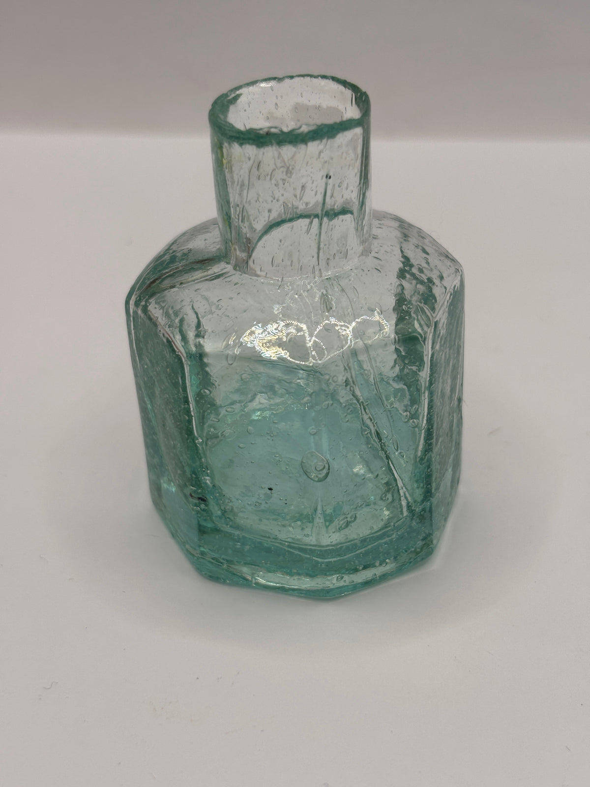 Old aqua glass inkwell, bubbly ink