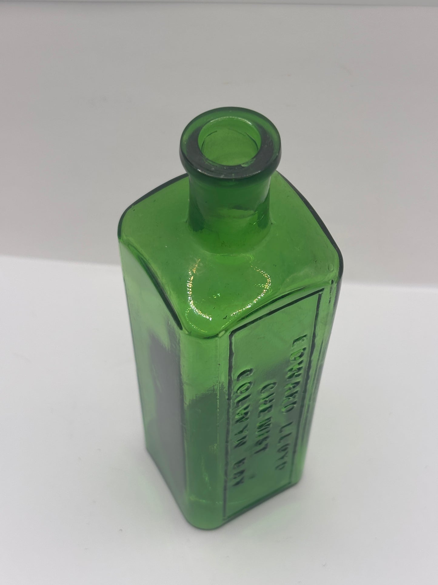 Old green glass advertising chemist bottle. Edward Lloyd chemist Colwyn bay