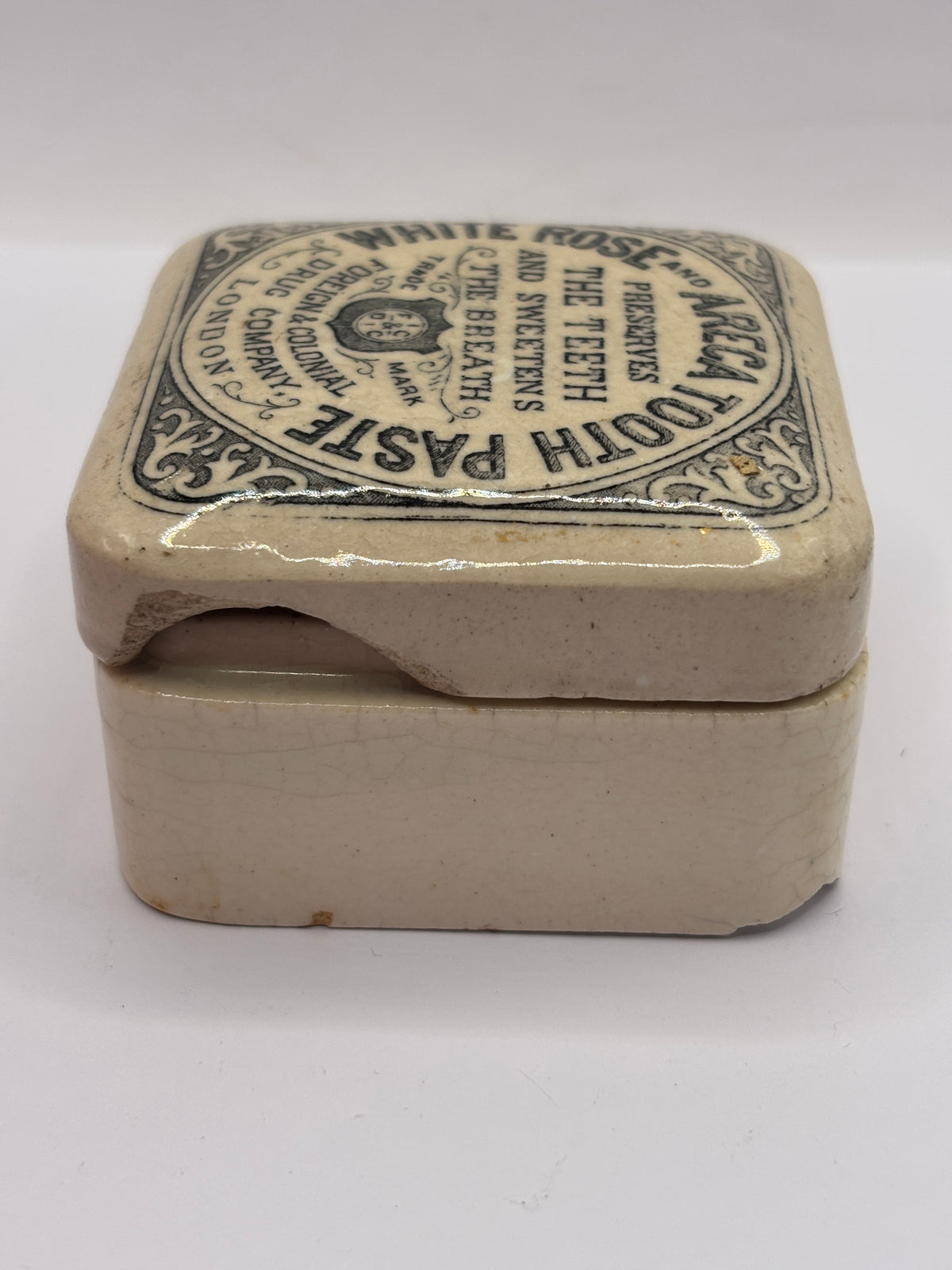 Old advertising lid and base. White rose and areca toothpaste. Damaged