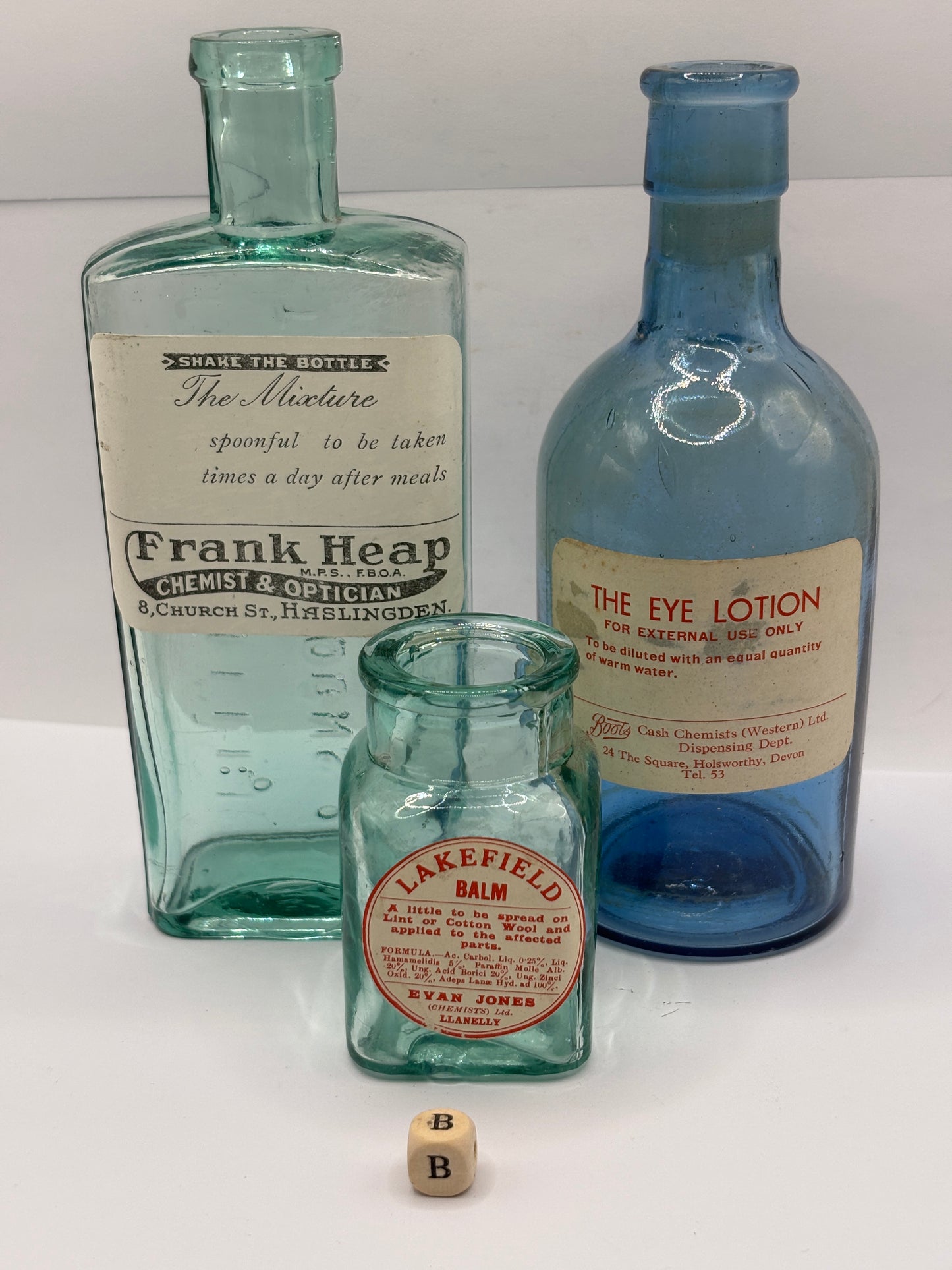 3 old glass chemist bottles with added labels