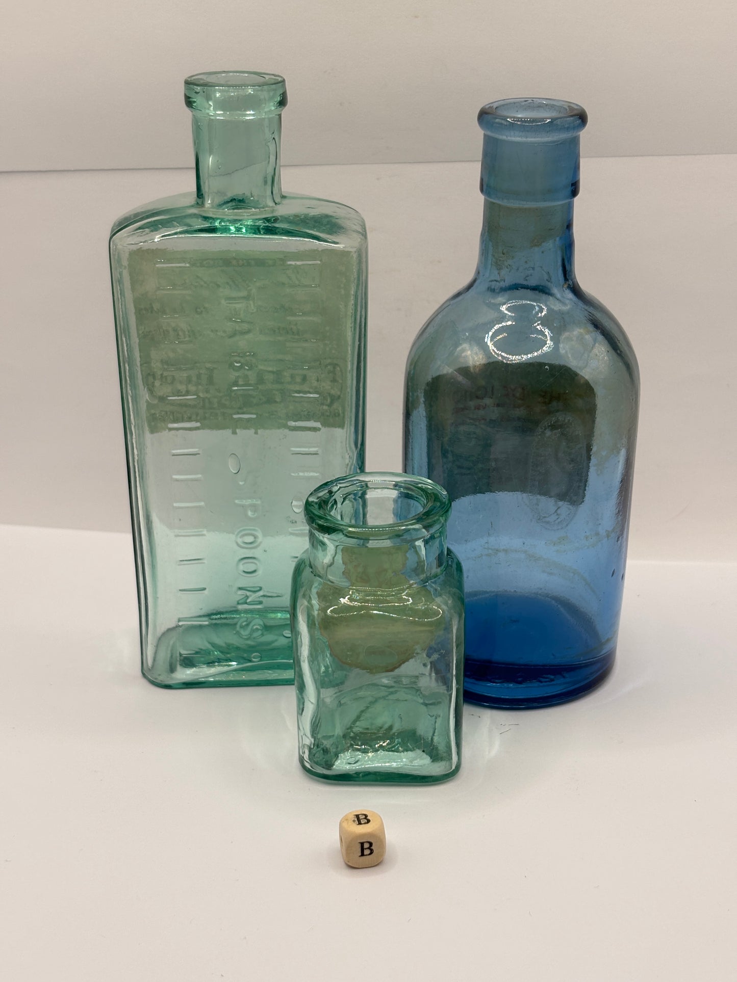 3 old glass chemist bottles with added labels