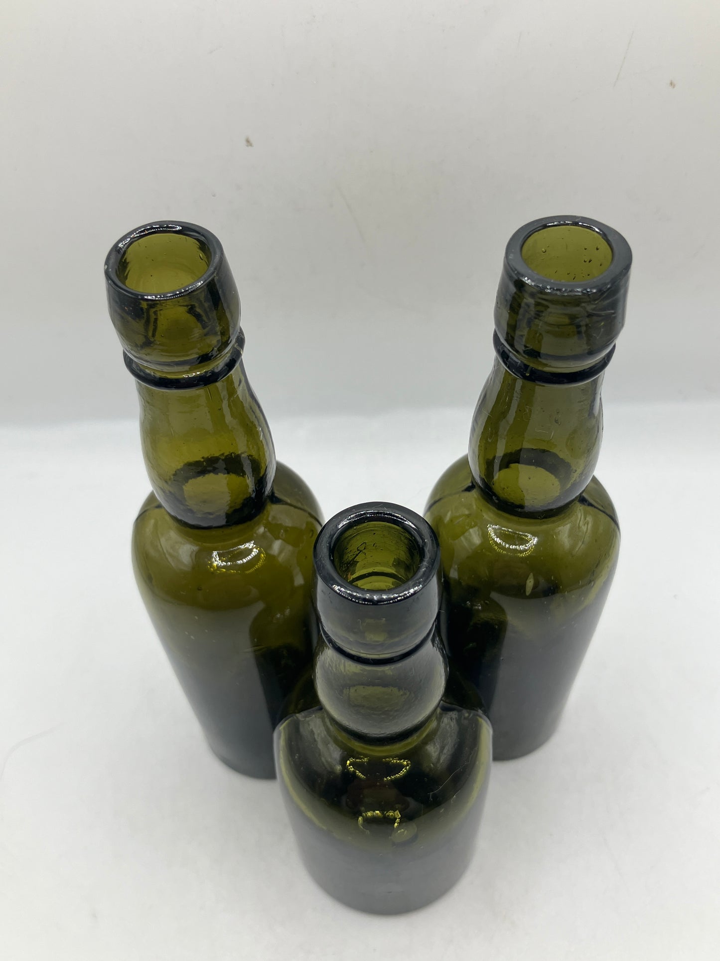 3 small green glass whisky bottles