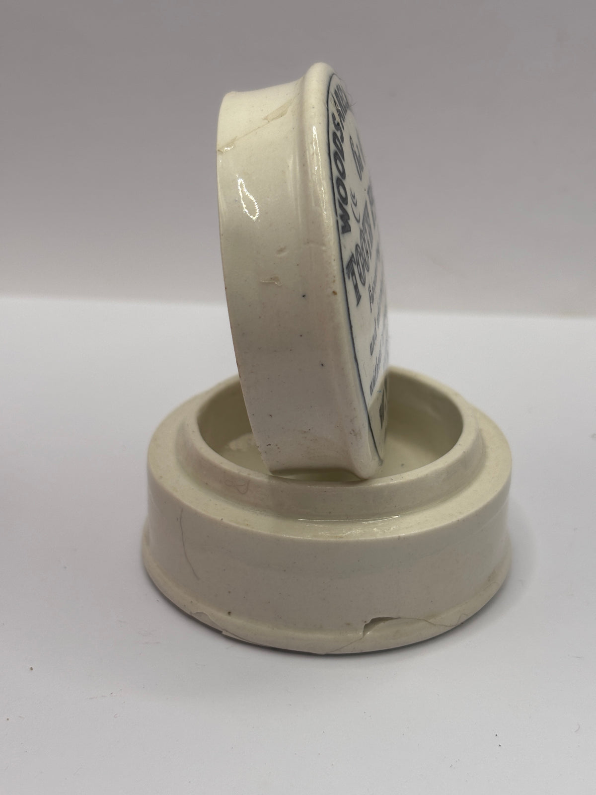 Old advertising lid and base. Woods areca nut tooth paste. Damaged