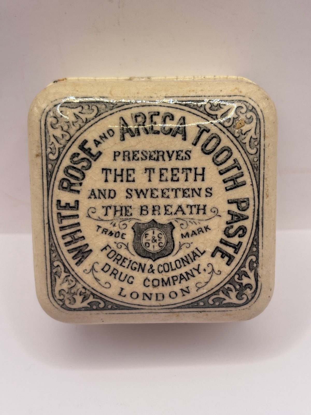 Old advertising lid and base. White rose and areca toothpaste. Damaged