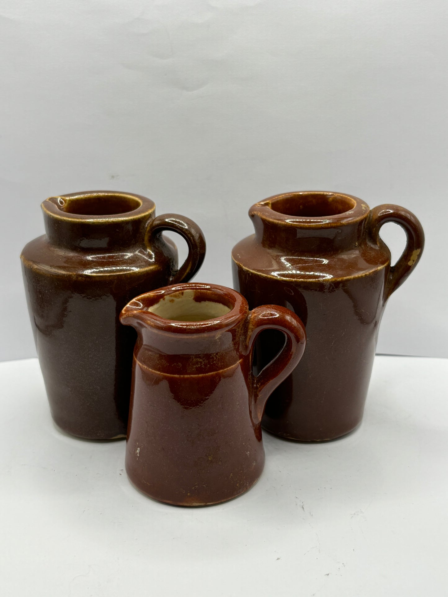 3 old brown stoneware cream pots, handled