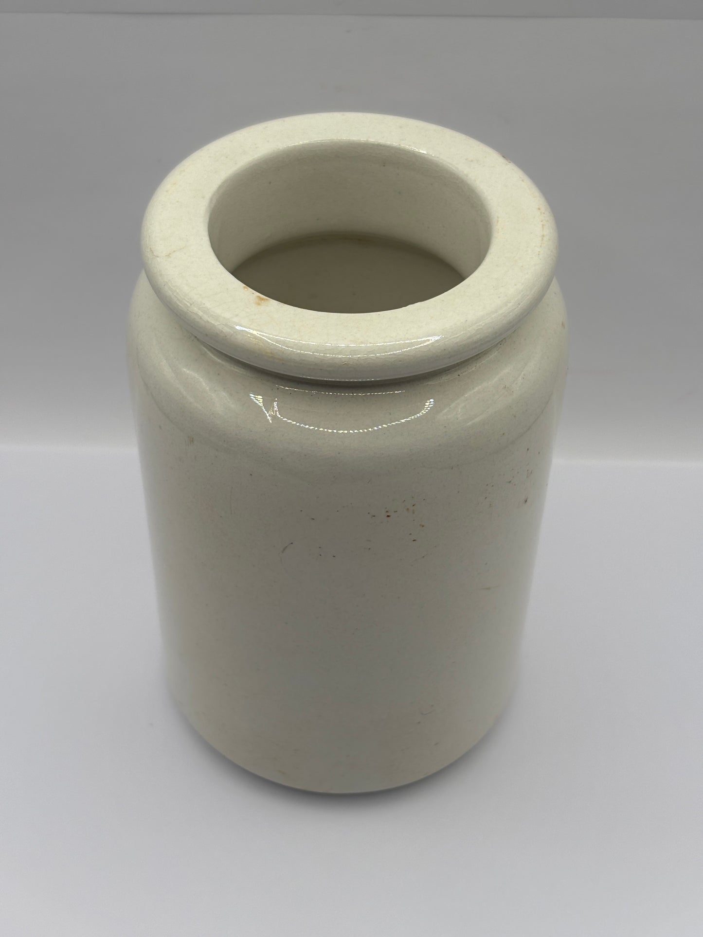 Old tall white rolled top stoneware jar