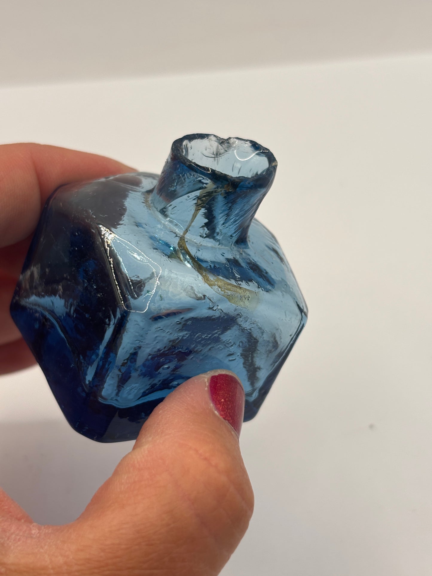 Old blue glass inkwell, penny ink with swirls. Damaged