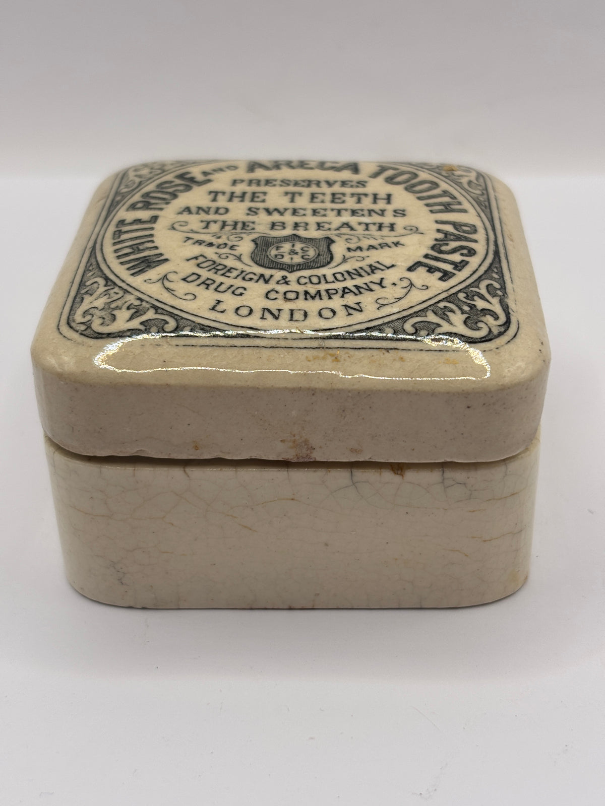 Old advertising lid and base. White rose and areca toothpaste. Damaged