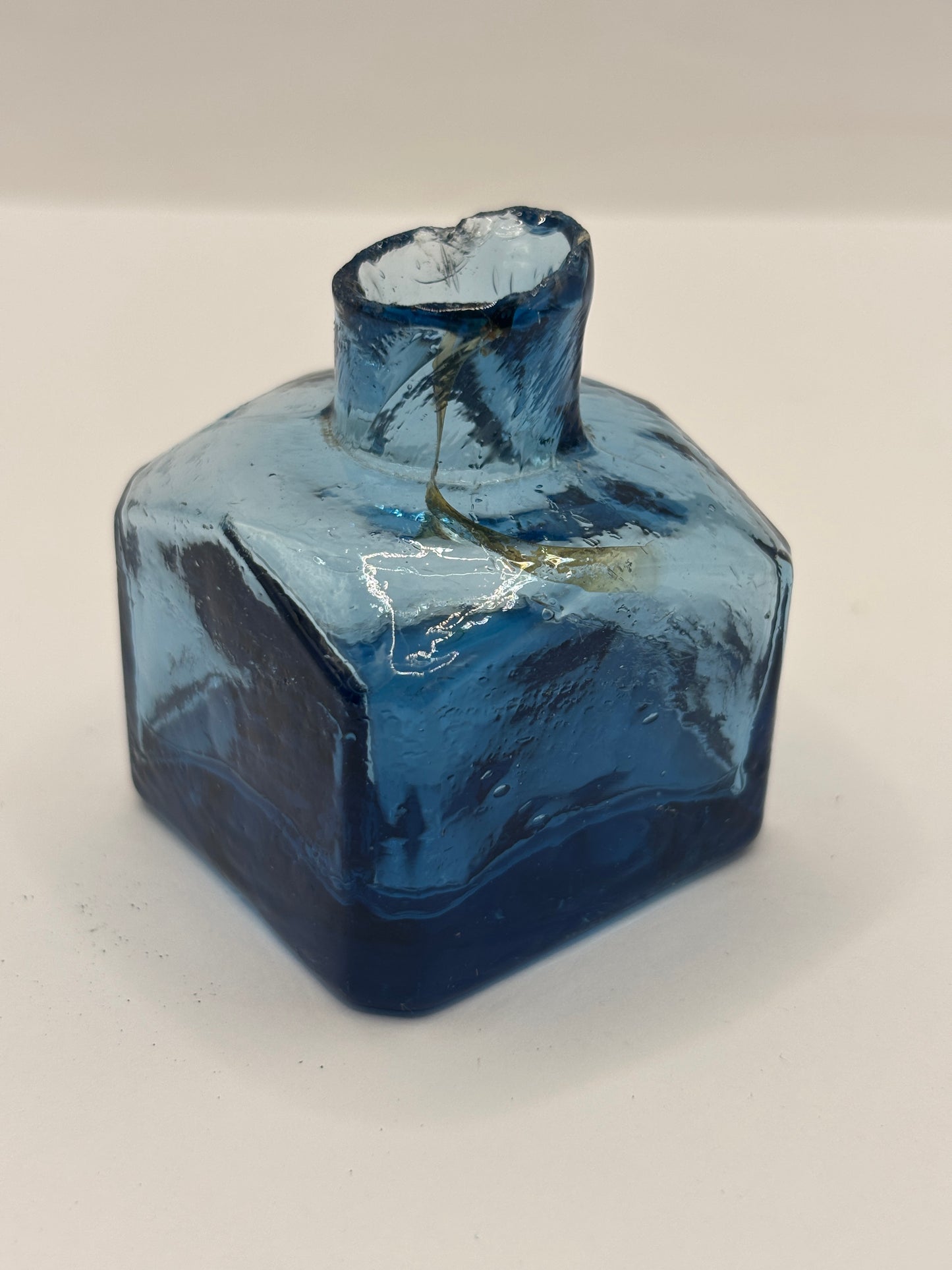 Old blue glass inkwell, penny ink with swirls. Damaged
