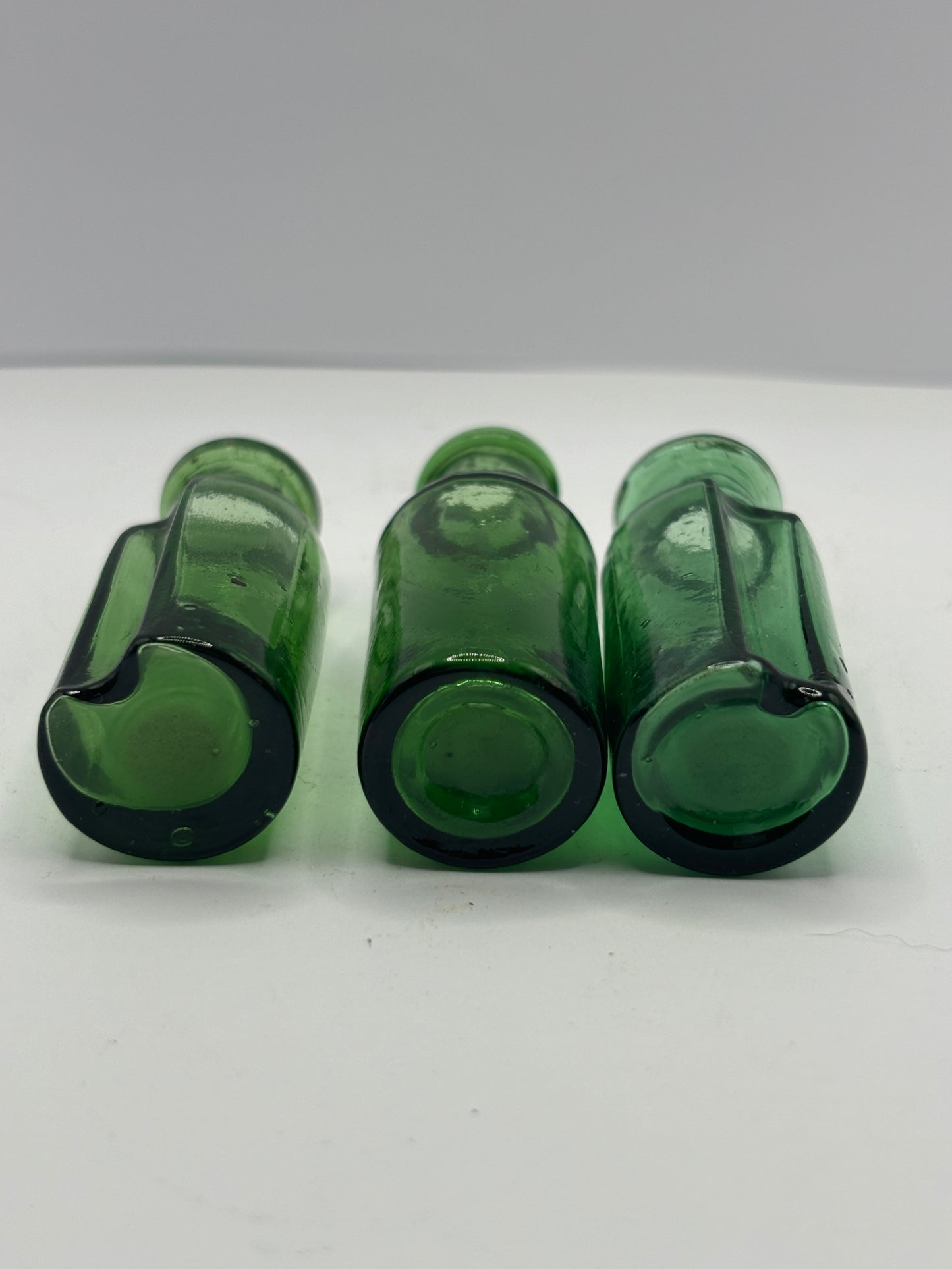 3 small green glass bottles