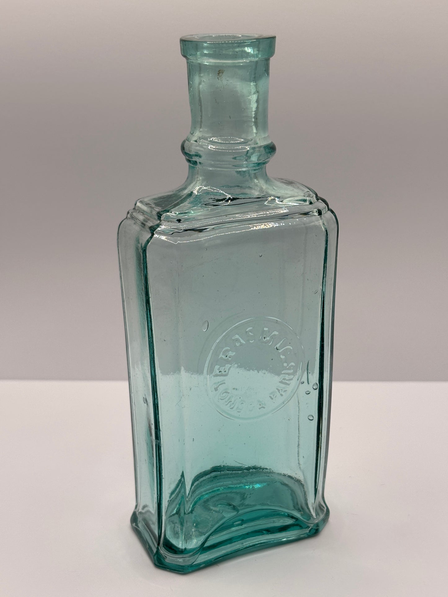 Old aqua glass advertising bottle. Perfume? Erasmic London Paris